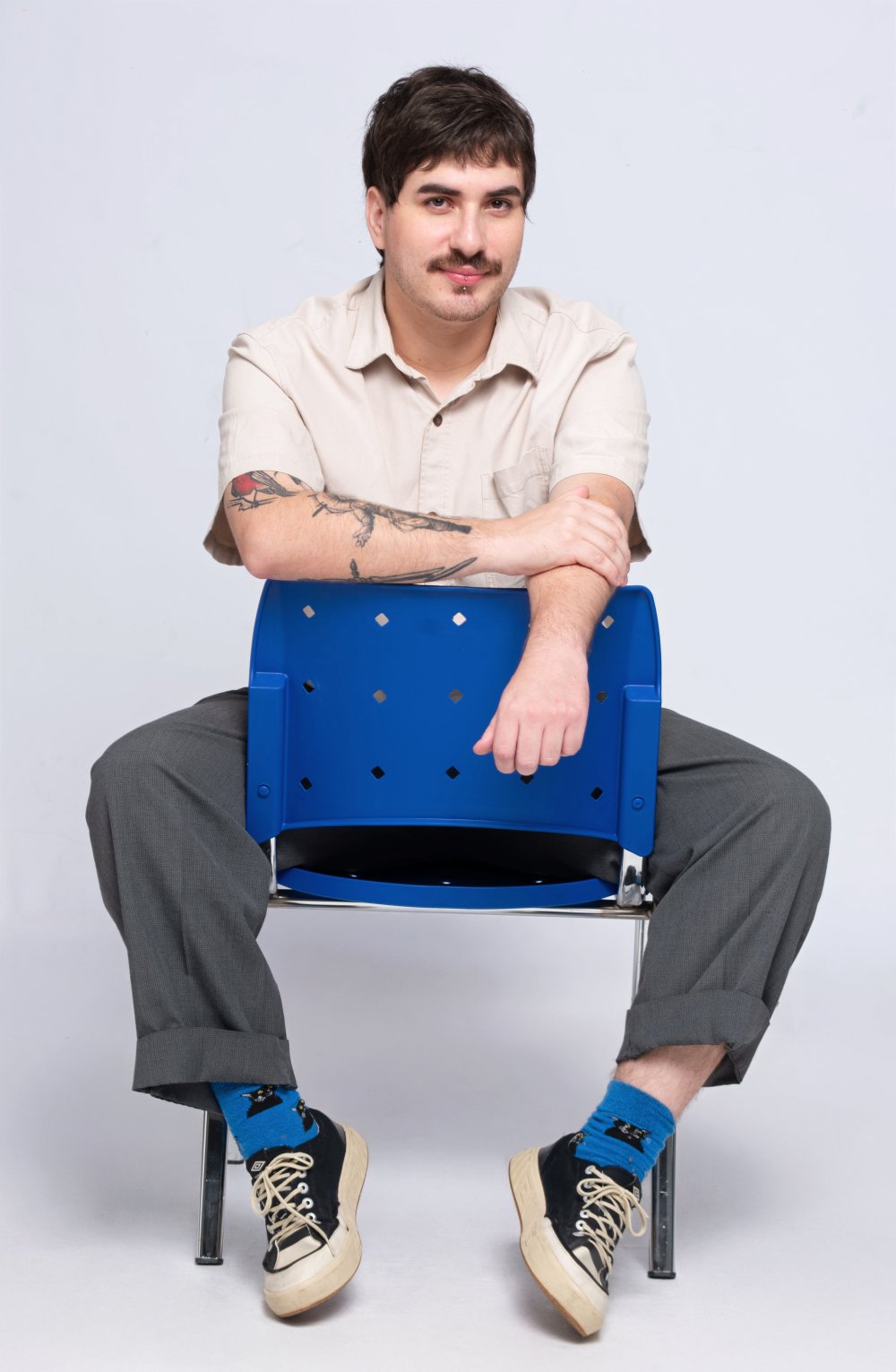 Jean Rosa, fundador da Buta, sentado em uma cadeira azul
